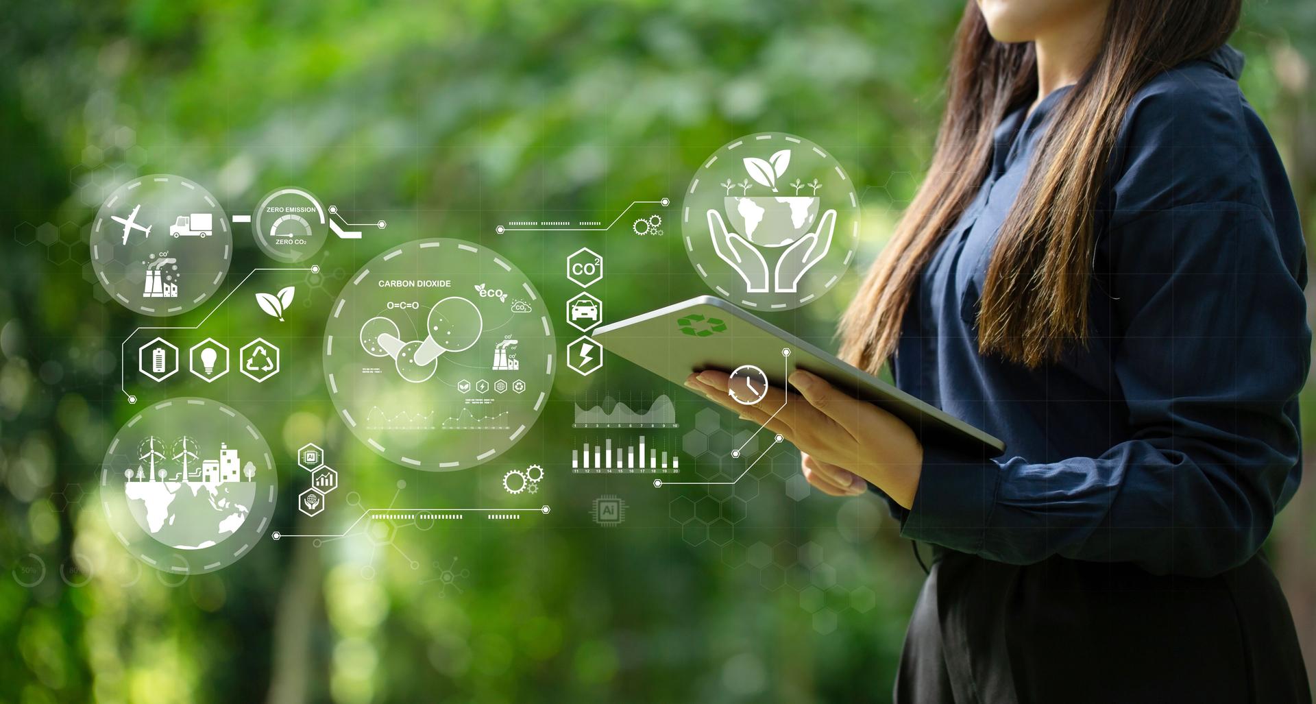 A woman holding a laptop with energy icons. green business. Ecosystem and Organization Development Cooperation. green production and waste recycling with regard to business.Carbon neutrality net zero.